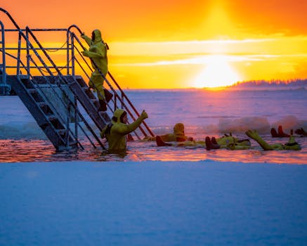 Group of people in yellow suits ice bathing at sunrise with vibrant sky.