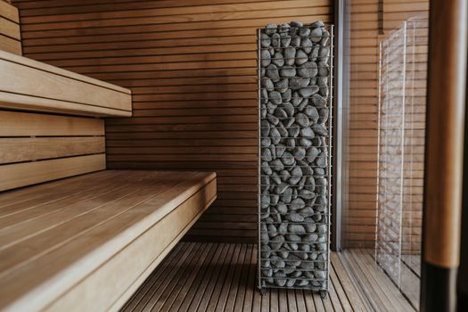A tranquil sauna room featuring stacked rocks and wooden benches, promoting relaxation and wellness.