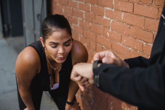 Woman in sportswear catching breath after intense exercise outdoors.