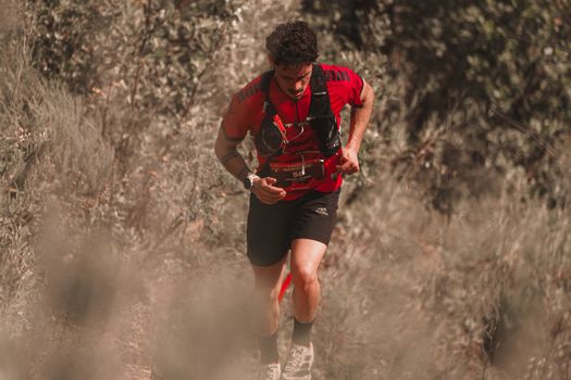Athletic man trail running in a natural setting, showcasing endurance and determination.