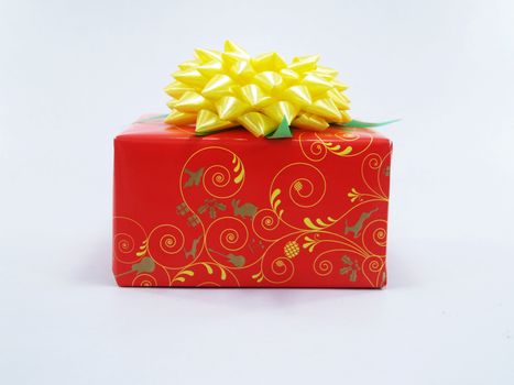 A brightly wrapped red gift box with a yellow bow, perfect for celebrations and special occasions.