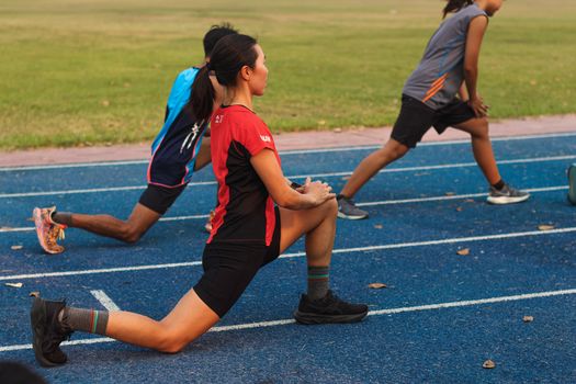 Group of athletes warming up on a track field in Mandalay, Myanmar.